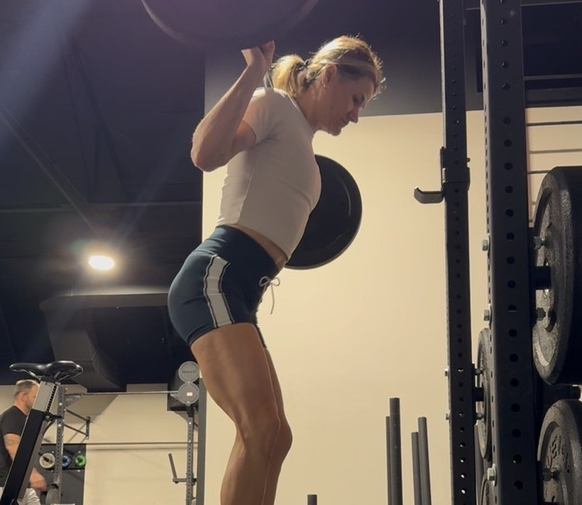 An athlete standing tall out of a barbell squat