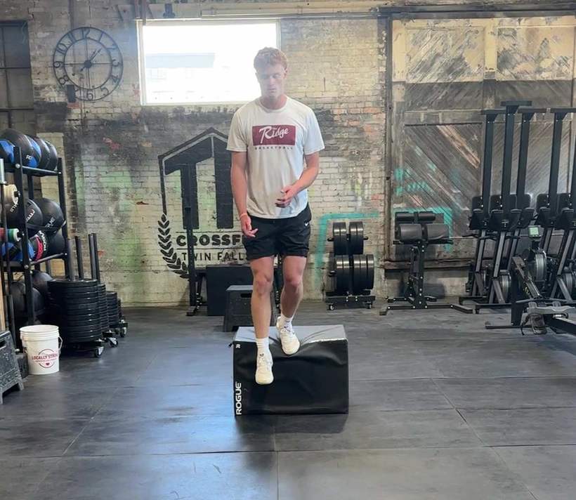 A young athlete stepping down from a plyometric box
