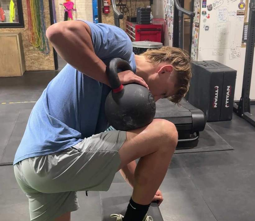 An athlete hinging with a kettlebell at the shoulder