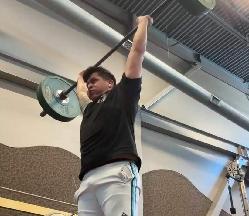 An athlete locking out a barbell overhead